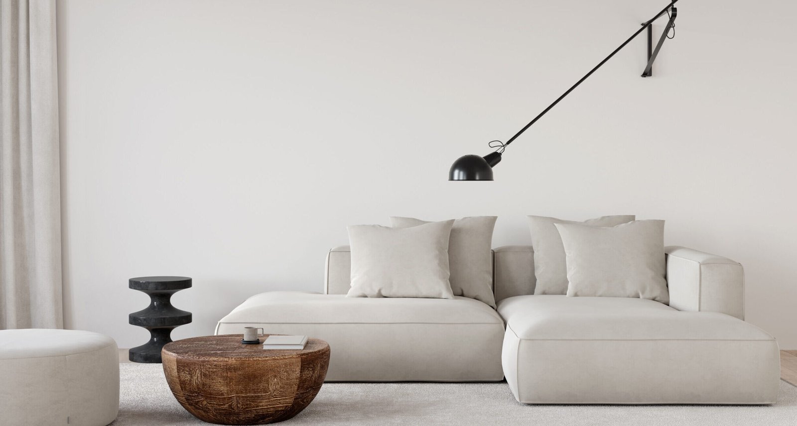 Interior of living room in off white color with a big soft sofa, a sconce, a wooden coffe table, a marble side table and pouf